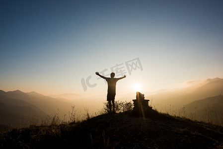 意大利帕索·马尼瓦山顶上举起双臂的人的背影