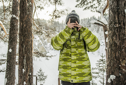 一名男子在积雪覆盖的森林中拍照俄罗斯
