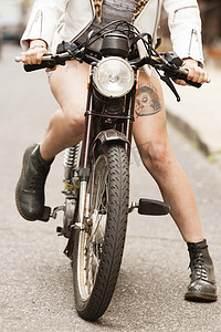 骑摩托车的年轻女子沿着公路低矮路段