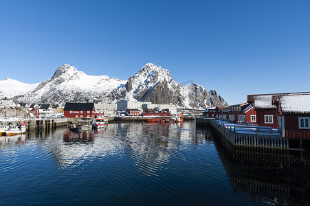 挪威罗福滕群岛斯沃尔沃的滨水房屋和白雪覆盖的山脉
