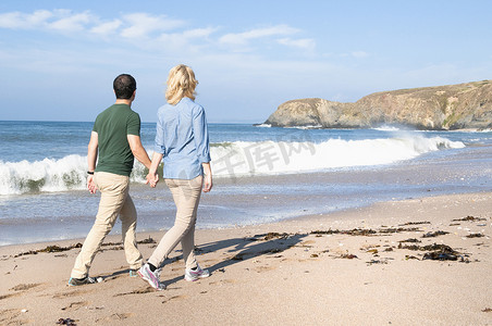 英国德文郡瑟尔斯通一对中年夫妇在海滩上散步
