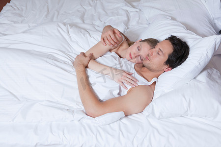 一对夫妻在床上拥抱着睡着了