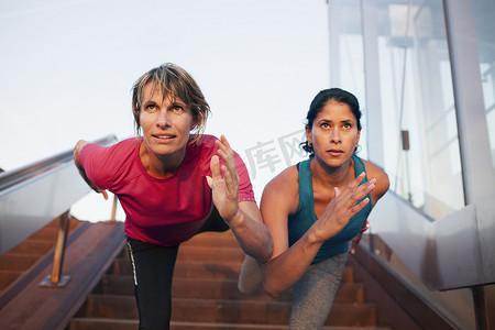 灵活性训练摄影照片_两名女子训练一条腿在楼梯上保持平衡