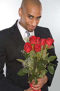 微笑的男人拿着一束玫瑰花