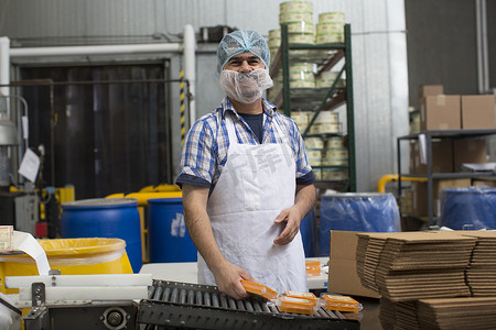商品套餐摄影照片_一名男子在仓库里包装素食奶酪
