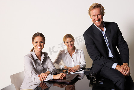 三位商人面带微笑地坐在一桌