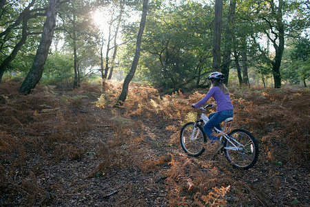 在森林里骑自行车的女孩