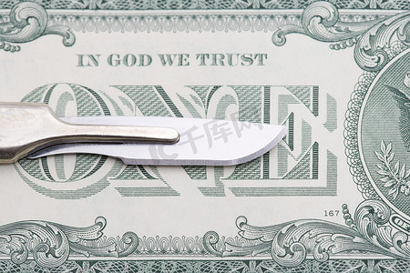 外科手术刀摄影照片_手术刀和一美元钞票