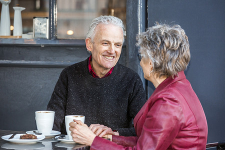 一对老夫妇在路边咖啡馆边喝咖啡边聊天