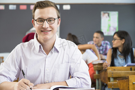 男学生肖像坐在教室的书桌前