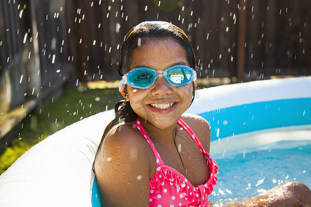 花园划水池中戴泳镜的女孩肖像