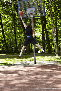 青年男子篮球运动员跳跃投篮的背影