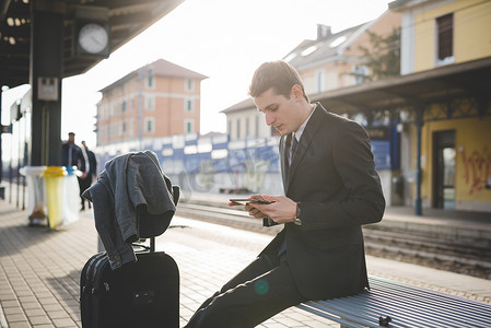 年轻商人通勤者在火车站使用数字平板电脑的肖像