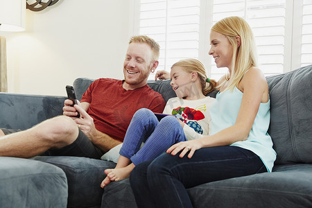 家人在客厅的沙发上聊天和使用智能手机