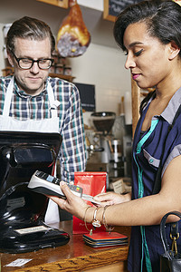 科技摄影照片_面包店顾客使用中间部分的刷卡机付款