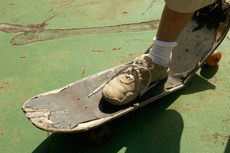 运动鞋摄影照片_脚踩坏了的滑板