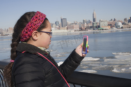 用智能手机拍摄天际线的年轻女孩纽约美国
