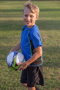 少年足球运动员在练习场上抱着足球的肖像