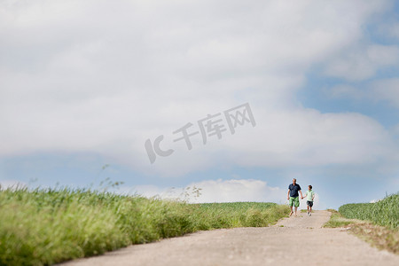 乡村大道摄影照片_父子俩走在一条路上