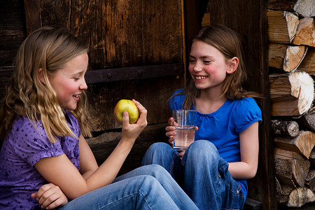 两个女孩吃着水果喝着水