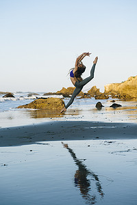 美国加利福尼亚州洛杉矶海滩上跳半空的年轻女芭蕾舞演员