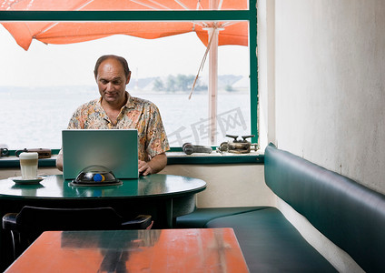 移门l绿色花纹摄影照片_一名男子在咖啡馆里用电脑工作
