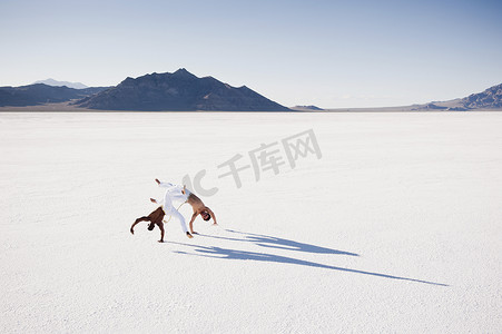 美国犹他州波纳维尔盐滩上两名男子表演卡波埃拉的高空景观