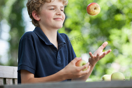 苹果游戏摄影照片_玩苹果杂耍的男孩