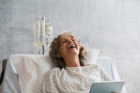 带数字平板电脑的女医院病人笑