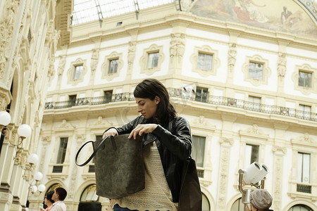 意大利米兰一名妇女在维托里奥·伊曼纽尔二世广场寻找肩包