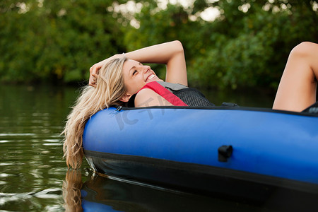 一名女子在小溪中的皮划艇上放松