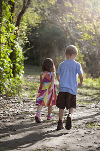 小男孩和小女孩走在土路上后视镜