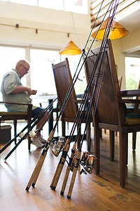 室内家居摄影照片_一名男子在餐厅里用钓竿工作