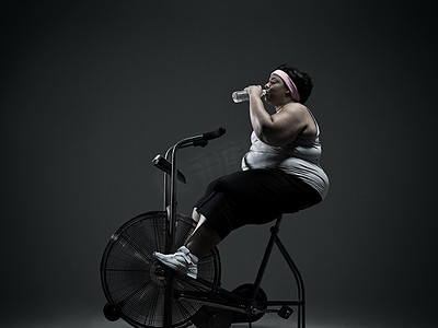 骑健身自行车的超重女人