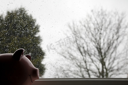 下雨水摄影照片_被雨水覆盖的窗户上的存钱罐