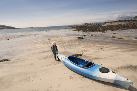 在海滩上划独木舟的男孩苏格兰赫布里底群岛斯凯岛的艾肖特湖