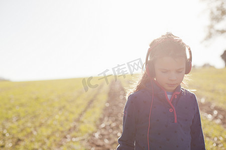 戴着金属探测耳机的女孩在田野里闲逛