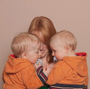 母亲抱着双胞胎儿子