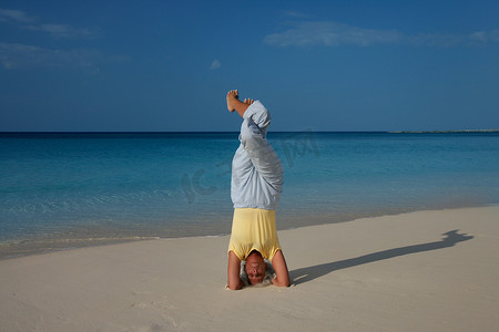 在热带海滩练习瑜伽的女人