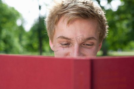十里红妆摄影照片_十几岁的男孩在公园里看书