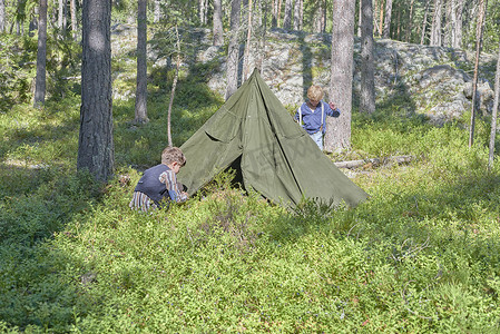 三生三世十里桃花摄影照片_两个穿着复古服装的弟弟在森林里搭帐篷