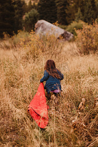 美国加利福尼亚州红杉国家公园年轻女孩在长长的草地上奔跑拖着睡袋后视镜矿泉王