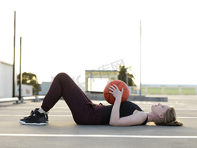 女篮摄影照片_年轻的女篮球运动员仰卧休息