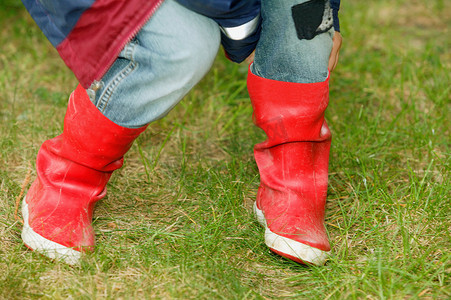 红靴子摄影照片_穿着红色靴子的孩子的腿