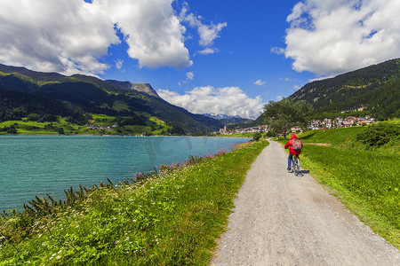 意大利南蒂罗尔山谷老年人在湖边骑自行车的后景