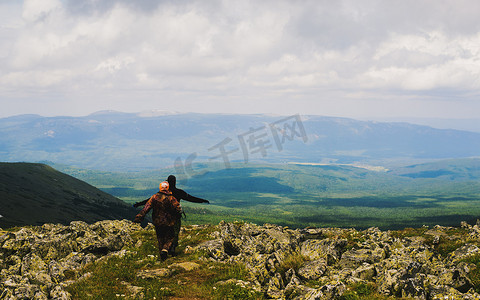 在崎岖的风景中徒步旅行的男人和女人的背影俄罗斯乌拉尔山脉