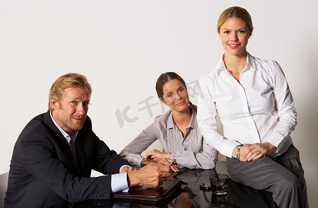 三位商人面带微笑地坐在一桌