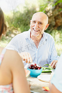 面带微笑的老人在野餐桌旁