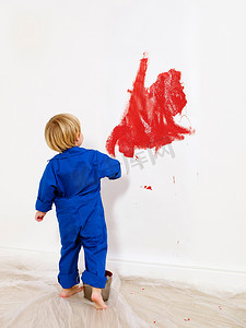 蹒跚学步的男孩把墙壁涂成红色