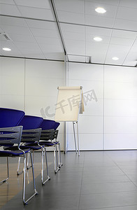 会议室内配有活动挂图和蓝色椅子